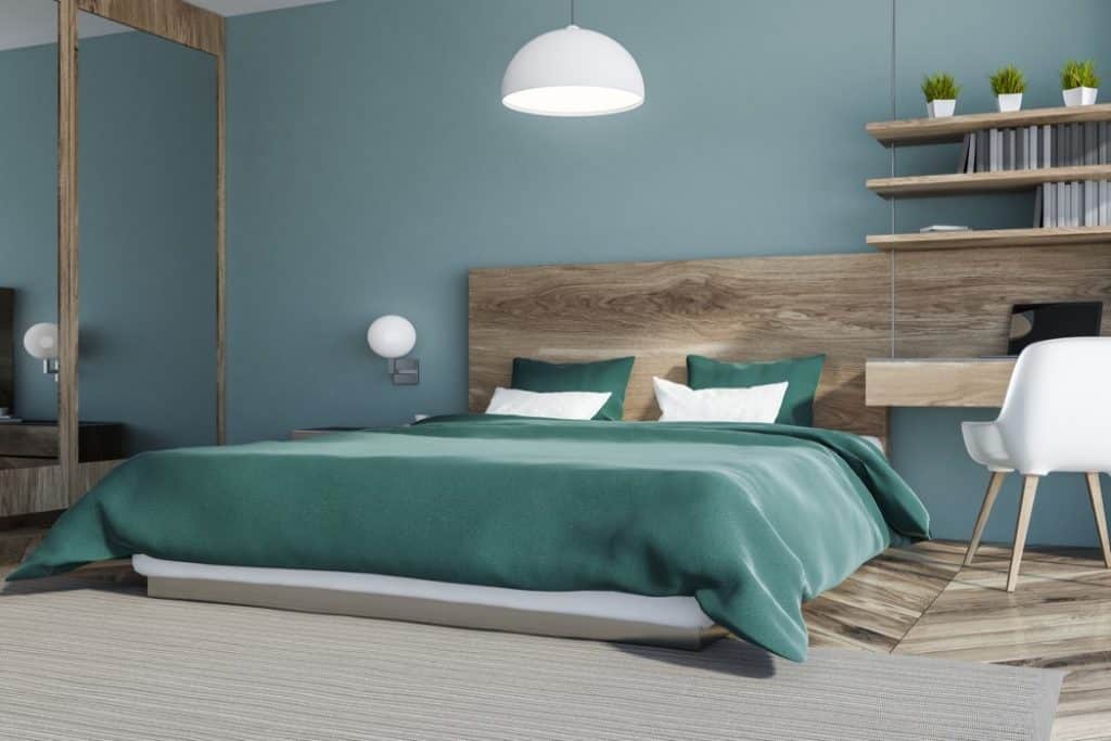 Corner of stylish bedroom with blue walls wooden floor - 101 Inspiring Master Bedroom Remodel Ideas & Pictures - HandyMan.Guide - Master Bedroom