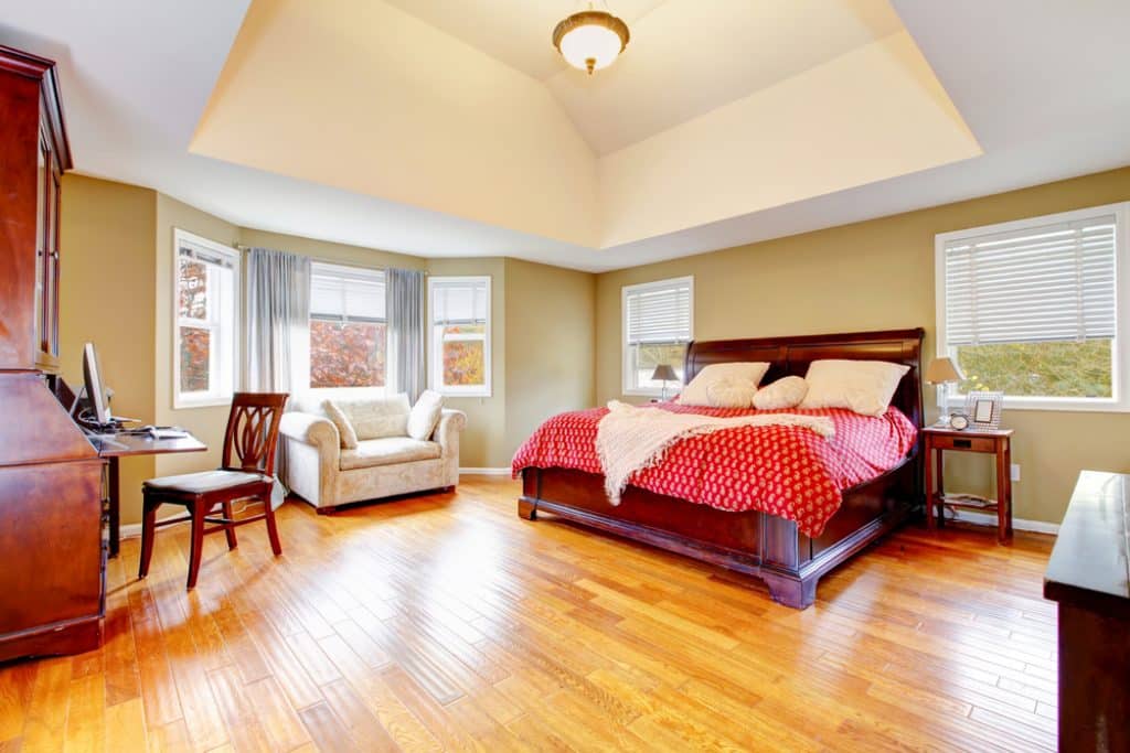 Large master bedroom interior with green alls and hardwood floor - 101 Inspiring Master Bedroom Remodel Ideas & Pictures - HandyMan.Guide - Master Bedroom