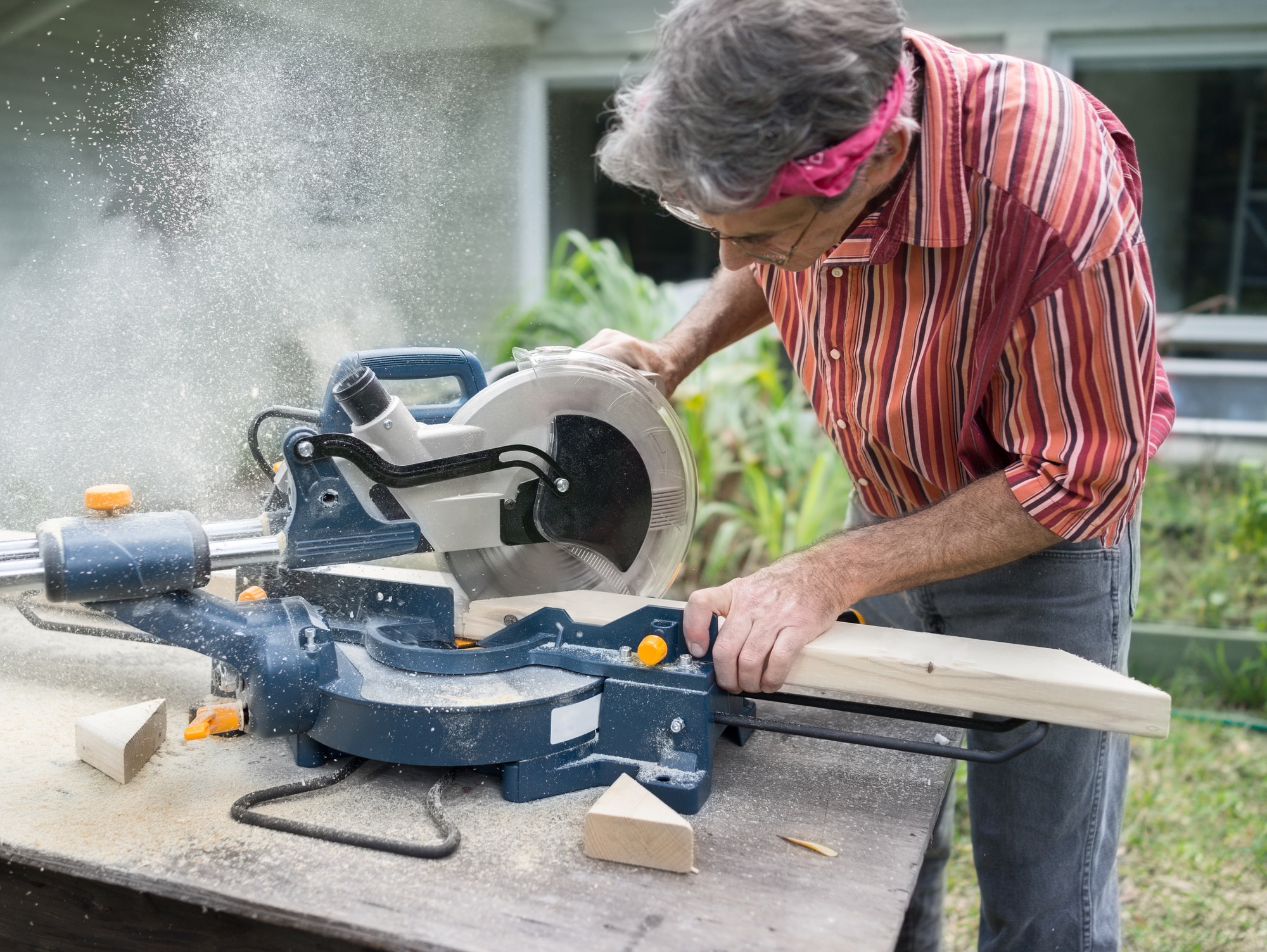 Man Sawing Wood with Sliding Compound Miter Saw