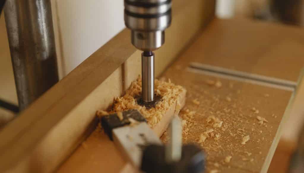 Boring machine drilling hole in wooden plank